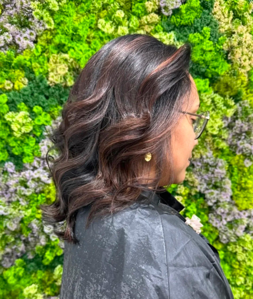 Balayage brun caramel sur cheveux ondulés réalisé dans notre salon de coiffure végétal à Vigneux-sur-Seine