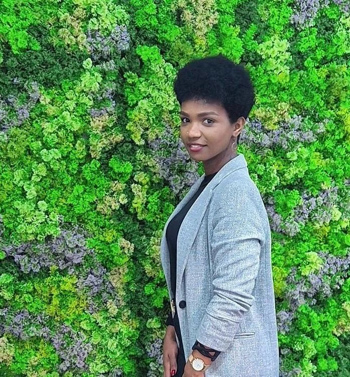 Portrait de la fondatrice du salon devant un mur végétal - salon de coiffure naturel à Vigneux-sur-Seine