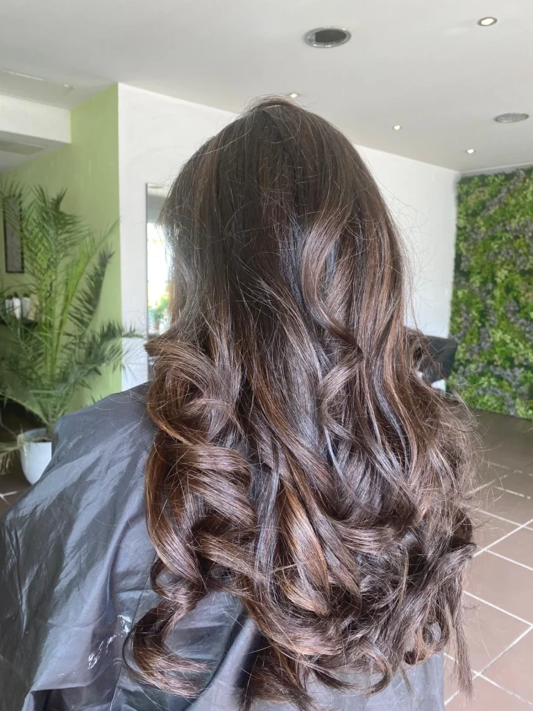 Cheveux longs bouclés après un balayage minéral dans notre salon de coiffure végétal & biologique à Vigneux-sur-Seine